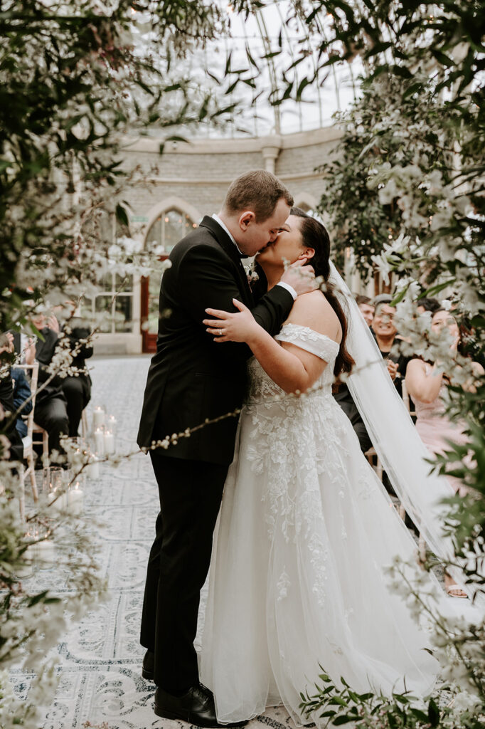 bride and groom sharing first kiss at tortworth court