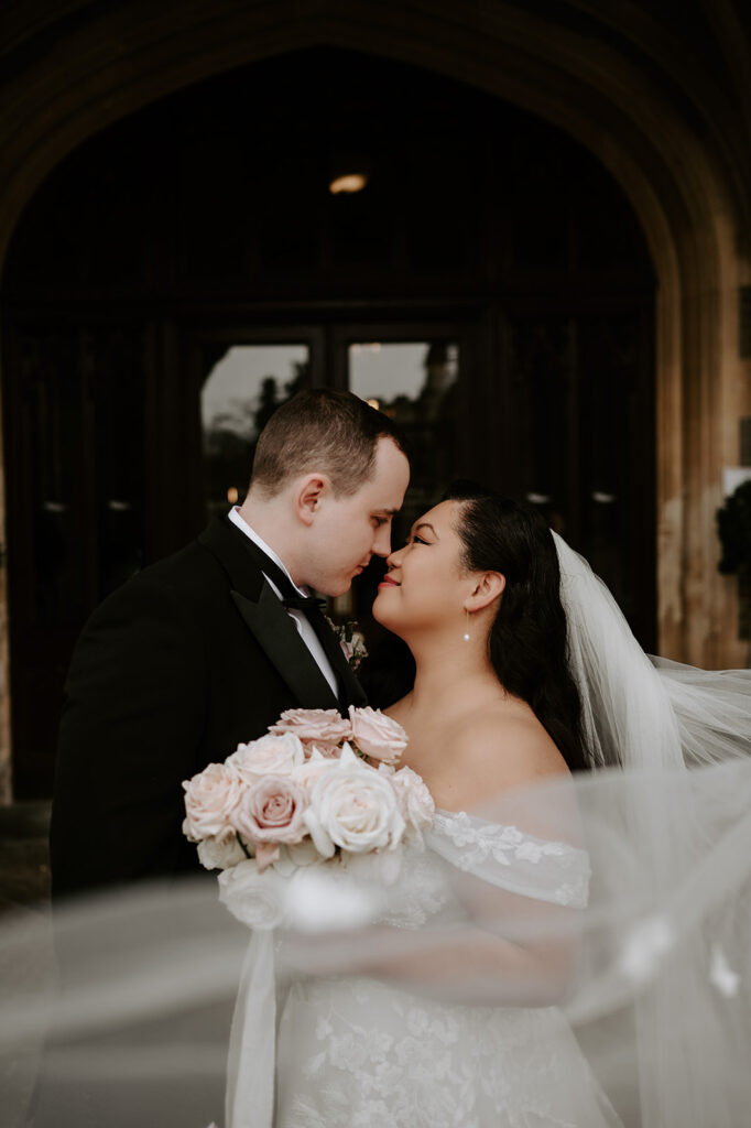 bride and groom with veil floating in wind