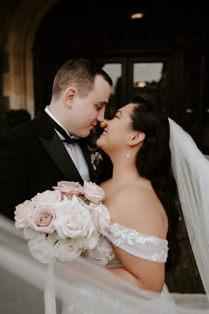 bride and groom with veil floating in wind
