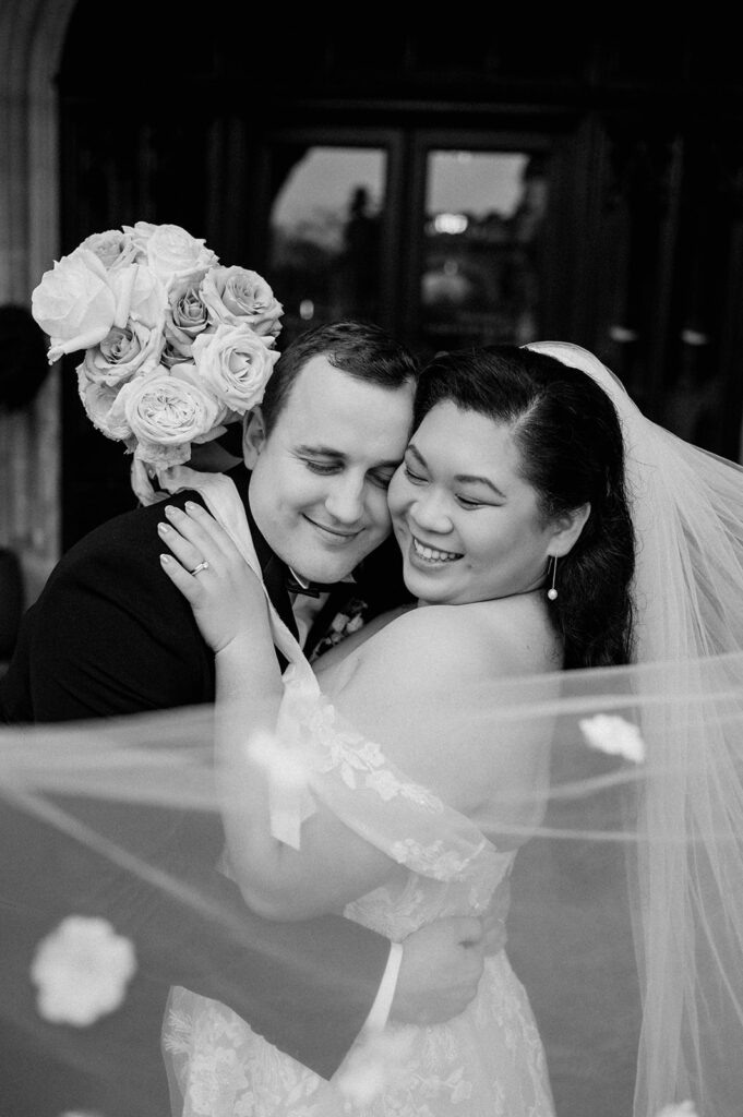 bride and groom with veil floating in wind holding blush pink rose bouquet