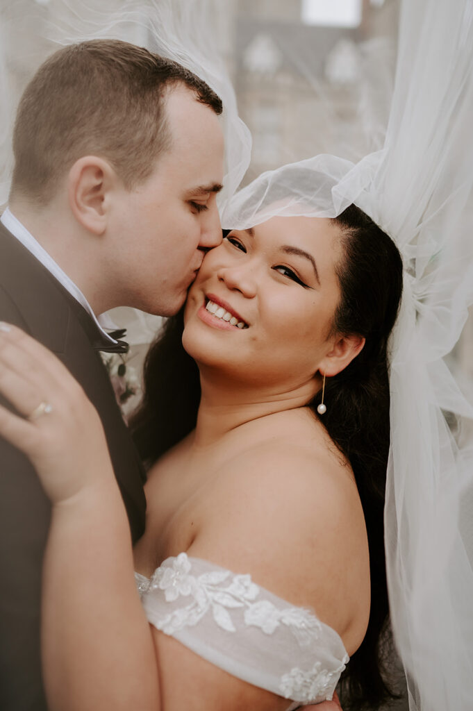 bride and groom under veil