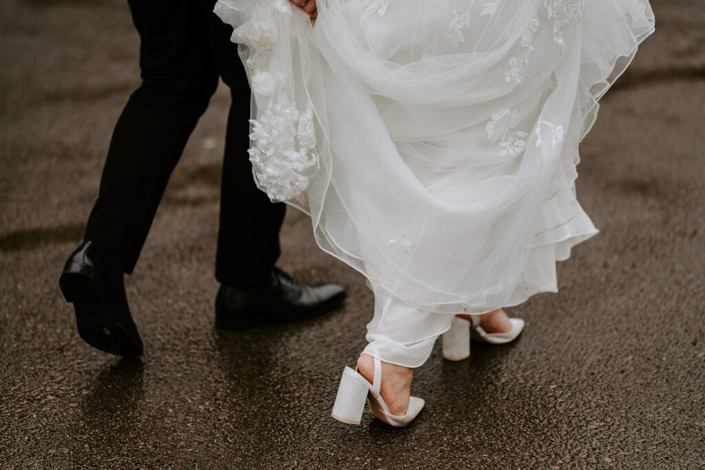 bride and groom walking in the rain