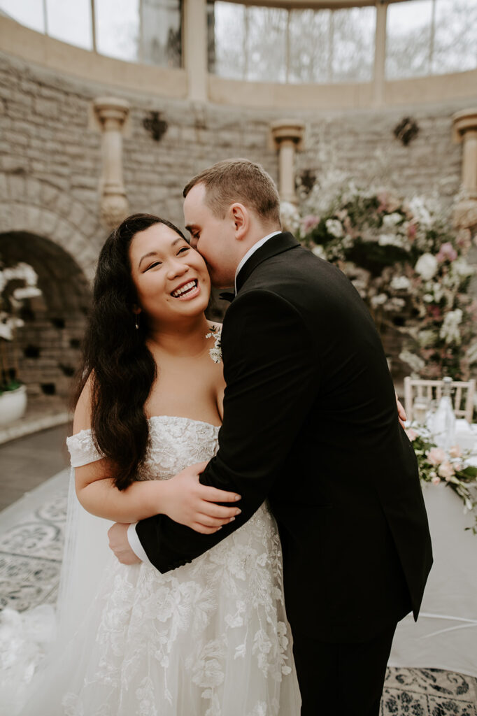 groom kissing bride on cheek