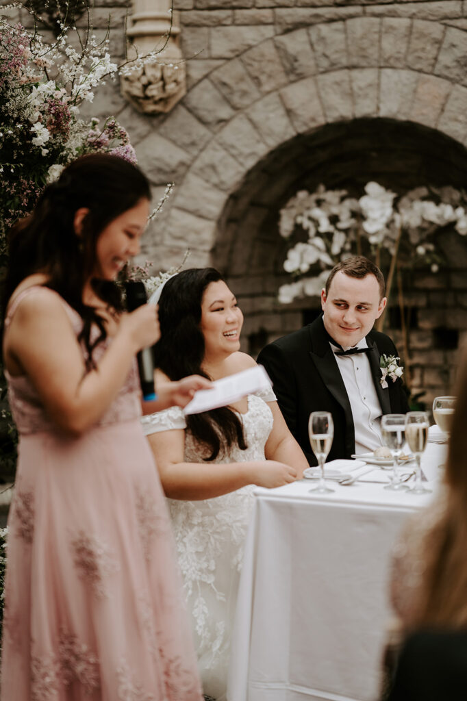 bride and groom laughing at wedding speeches