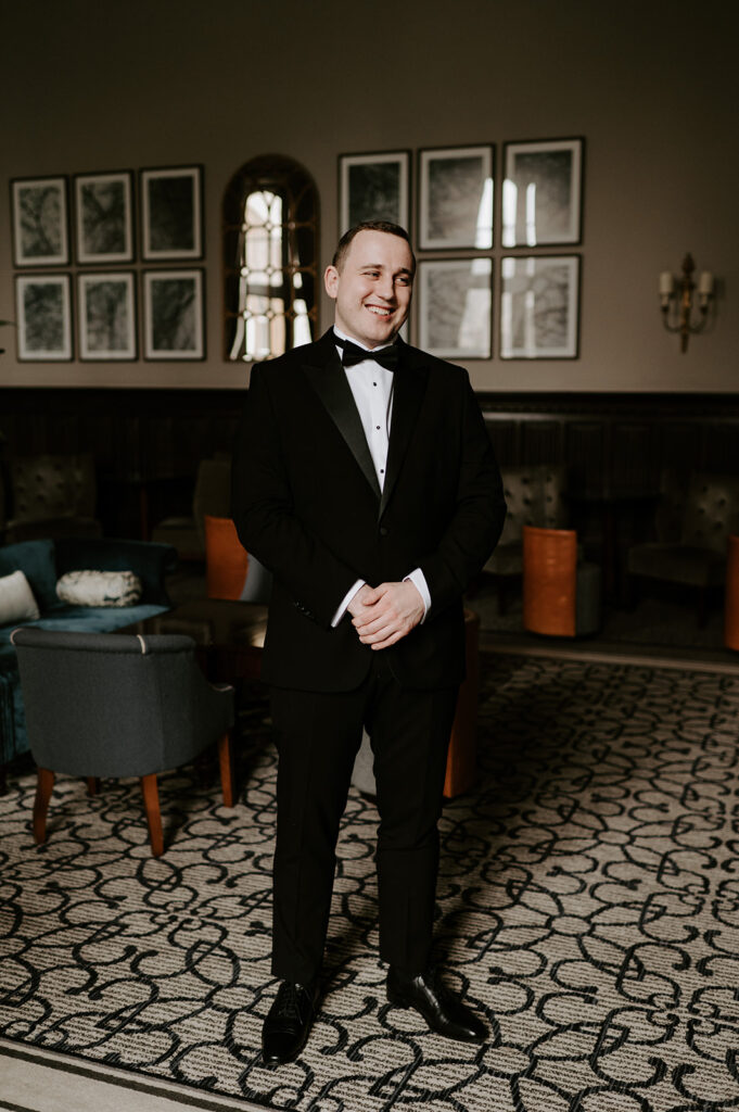 groom wearing black tie in bar at tortworth court