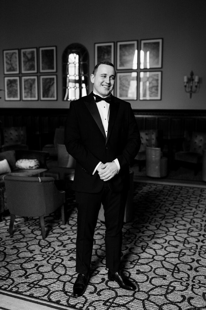 groom wearing black tie in bar at tortworth court