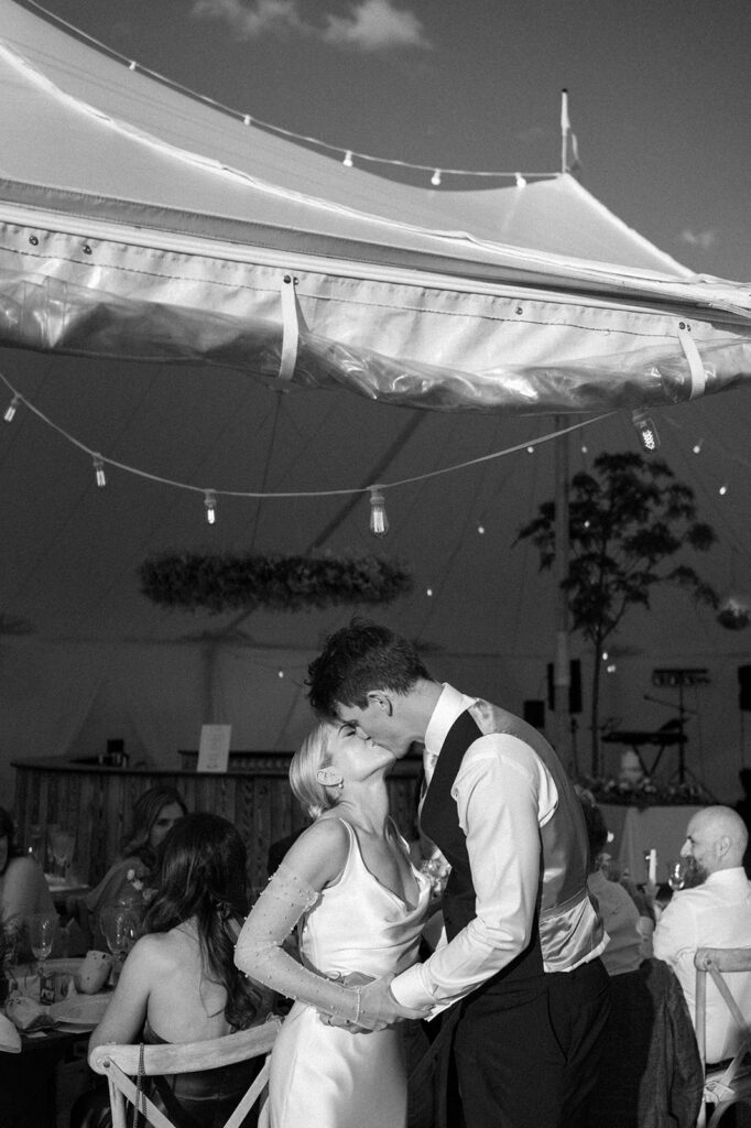 bride and groom sharing a kiss outside marquee at suffolk wedding