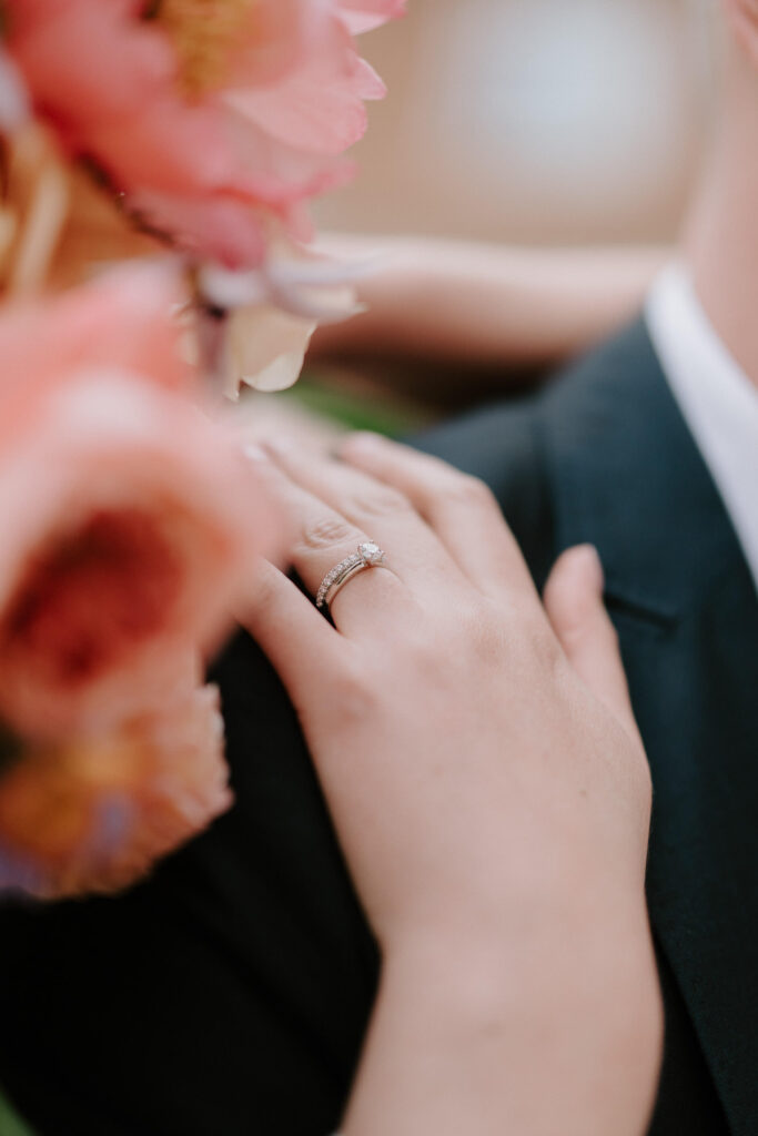 Close-up of the bride’s hand resting on the groom’s arm showing her wedding ring