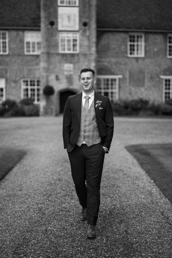 Groom walking towards bride outside Bruisyard Hall
