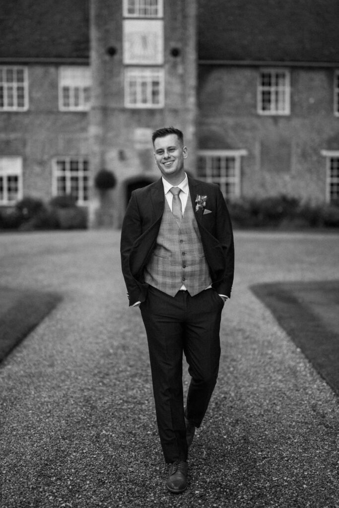 Groom smiling at bride outside Bruisyard Hall