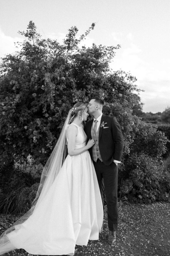groom kissing bride on forehead