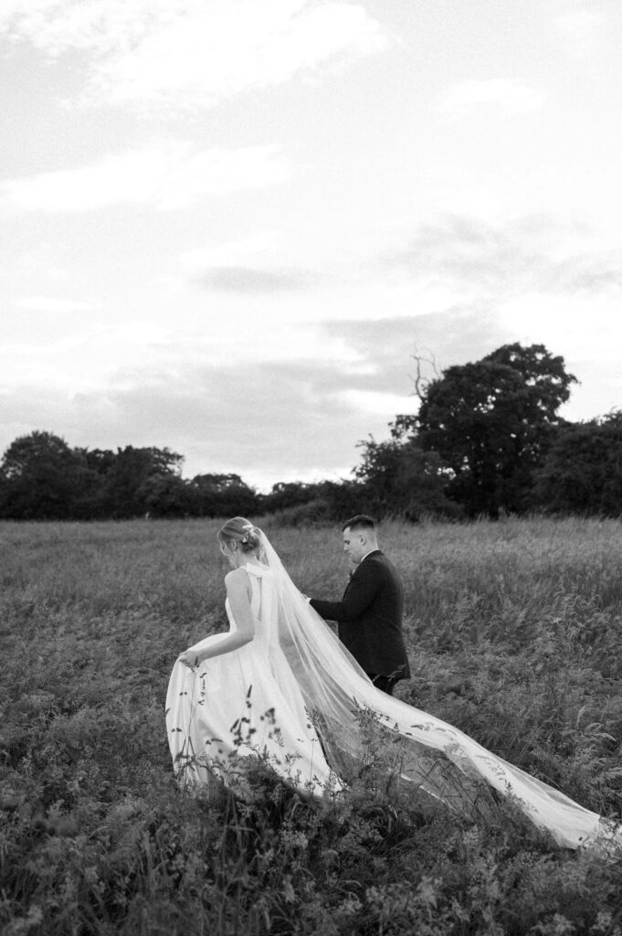 bride and groom walking away into sunset at bruisyard hall