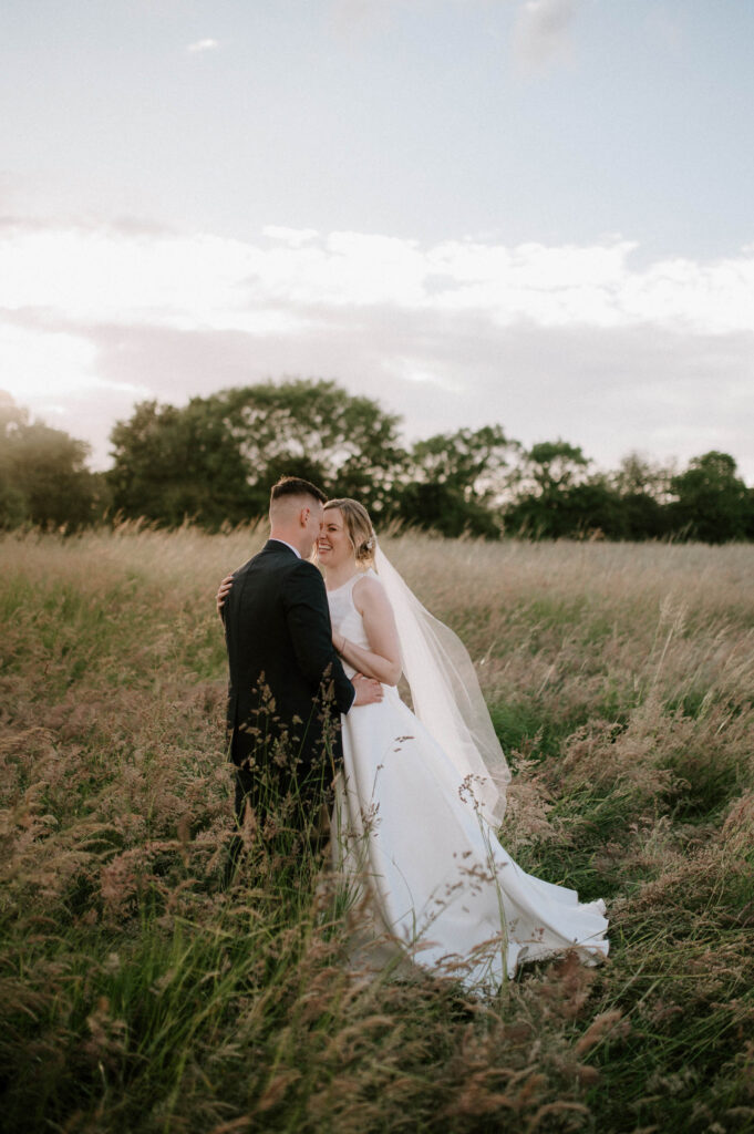 bride and groom portrait in field at bruisyard hall