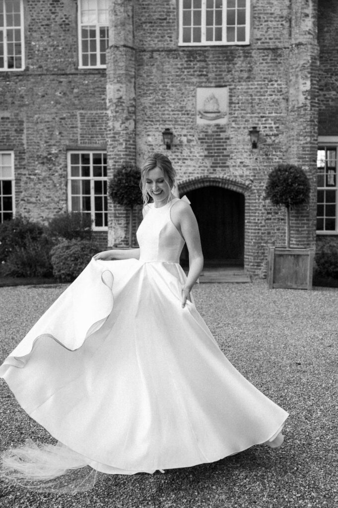 bride twirling and playing with her dress outside bruisyard hall