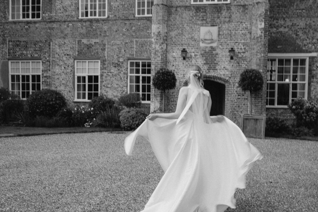 Bride spinning her wedding dress during portraits at Bruisyard Hall