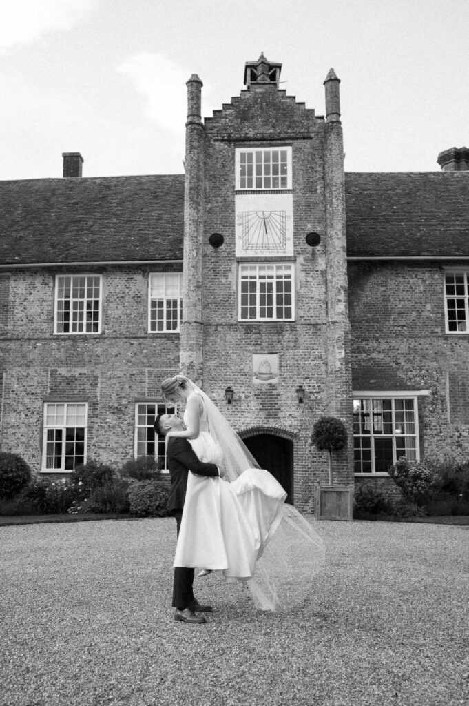 Bride and groom standing together outside Bruisyard Hall during couple portraits
