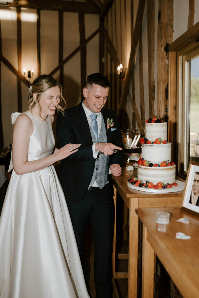 Bride and groom cutting their wedding cake together at Bruisyard Hall