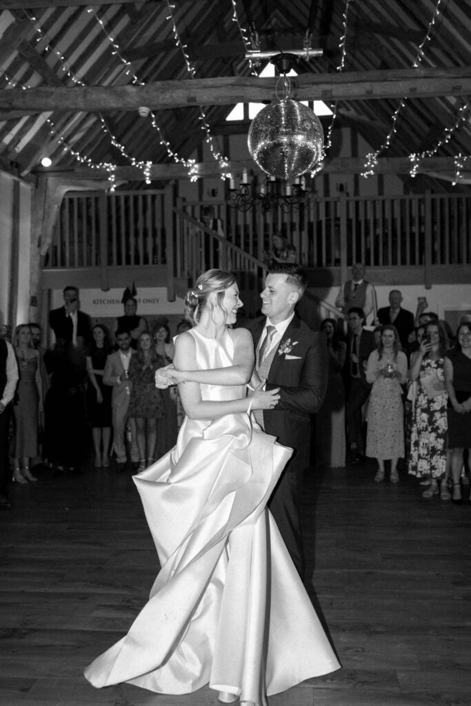 Bride and groom spinning together on the dance floor at Bruisyard Hall