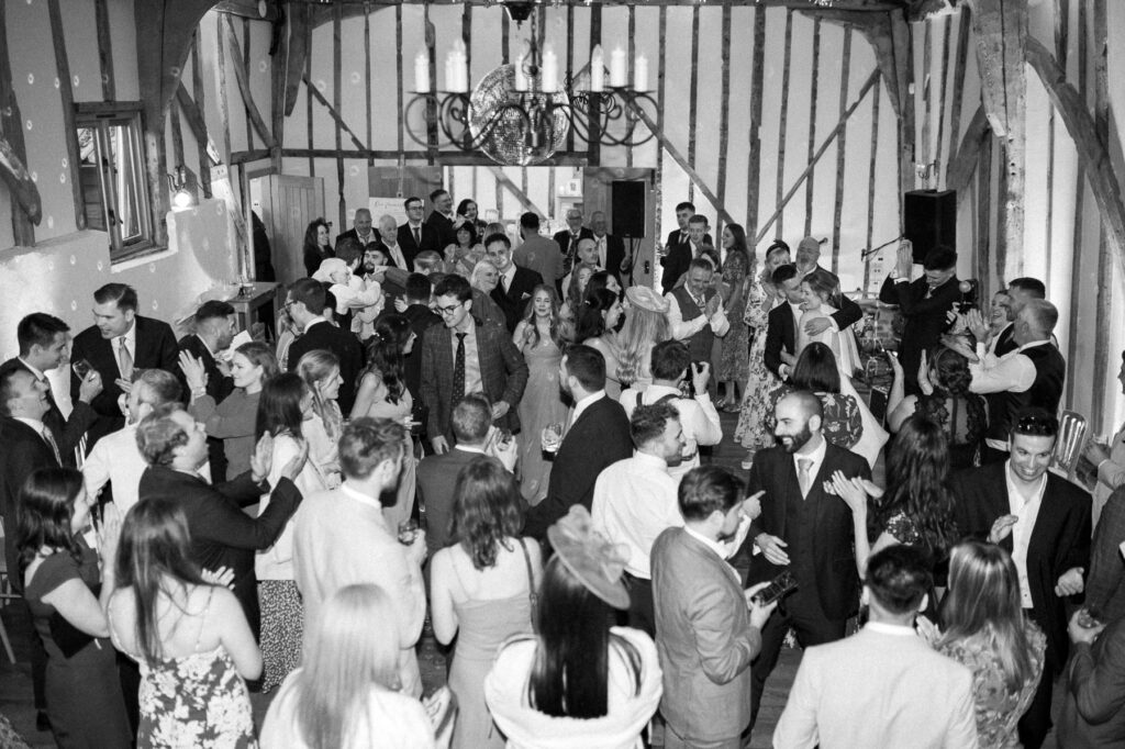 Full dance floor with guests dancing during the evening reception at Bruisyard Hall