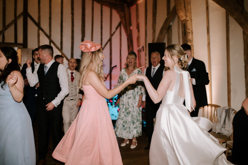Bride dancing with a guest during the evening reception at Bruisyard Hall