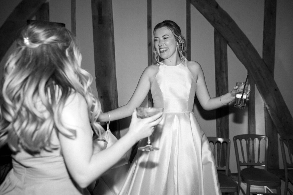Bride dancing and laughing during the evening reception at Bruisyard Hall