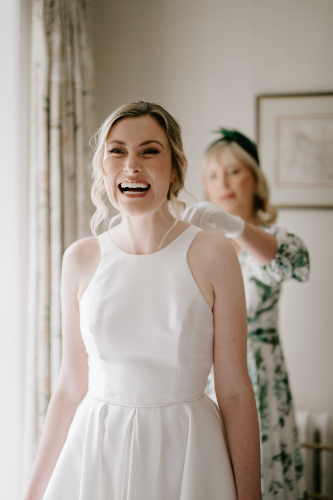 Bride Heidi laughing during bridal prep while getting ready at Bruisyard Hall