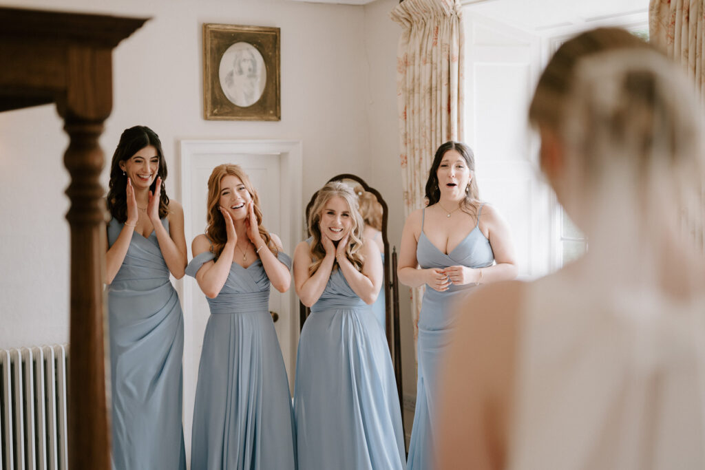 bridesmaids reacting to seeing the bride in her dress