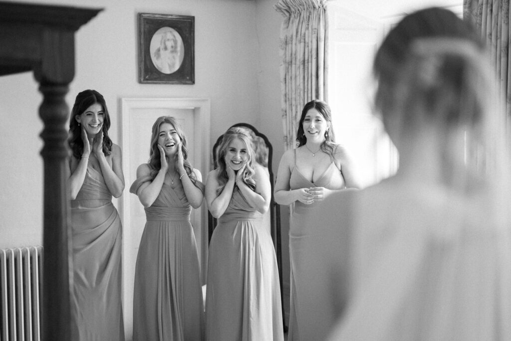photo of bridesmaids reacting to seeing the bride at Bruisyard Hall