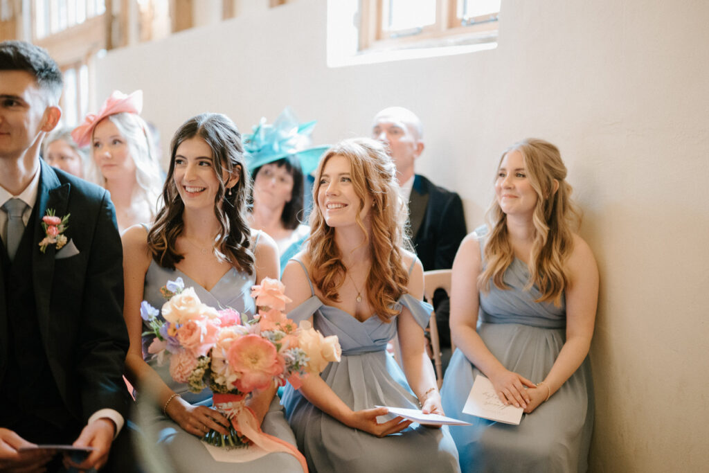 Bridesmaids smiling at the front during Heidi and Charley’s ceremony at Bruisyard Hall