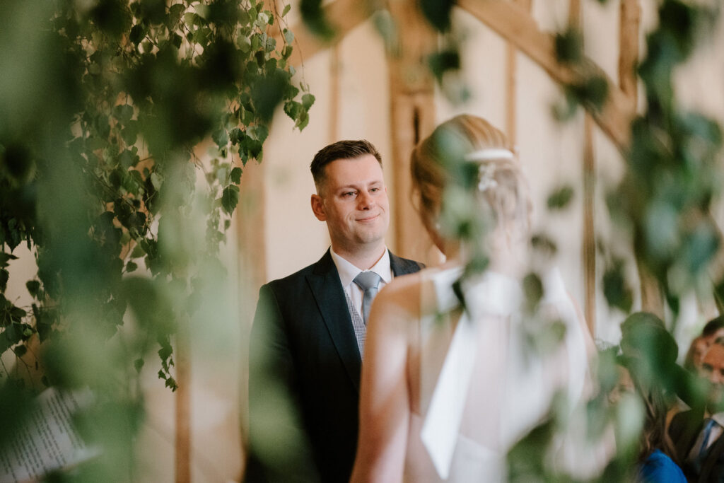 groom smiling at bride during ceremony