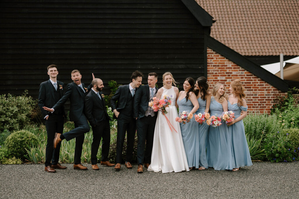 Bride and groom posing with their bridesmaids and groomsmen at Bruisyard Hall