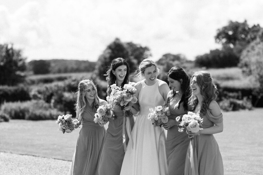 Bride laughing with her bridesmaids during portraits at Bruisyard Hall