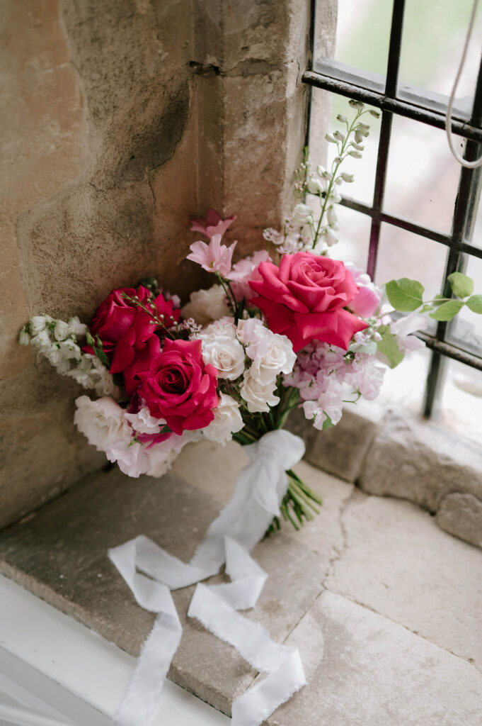 Bride’s pink and white rose bouquet at Butley Priory on windowsill