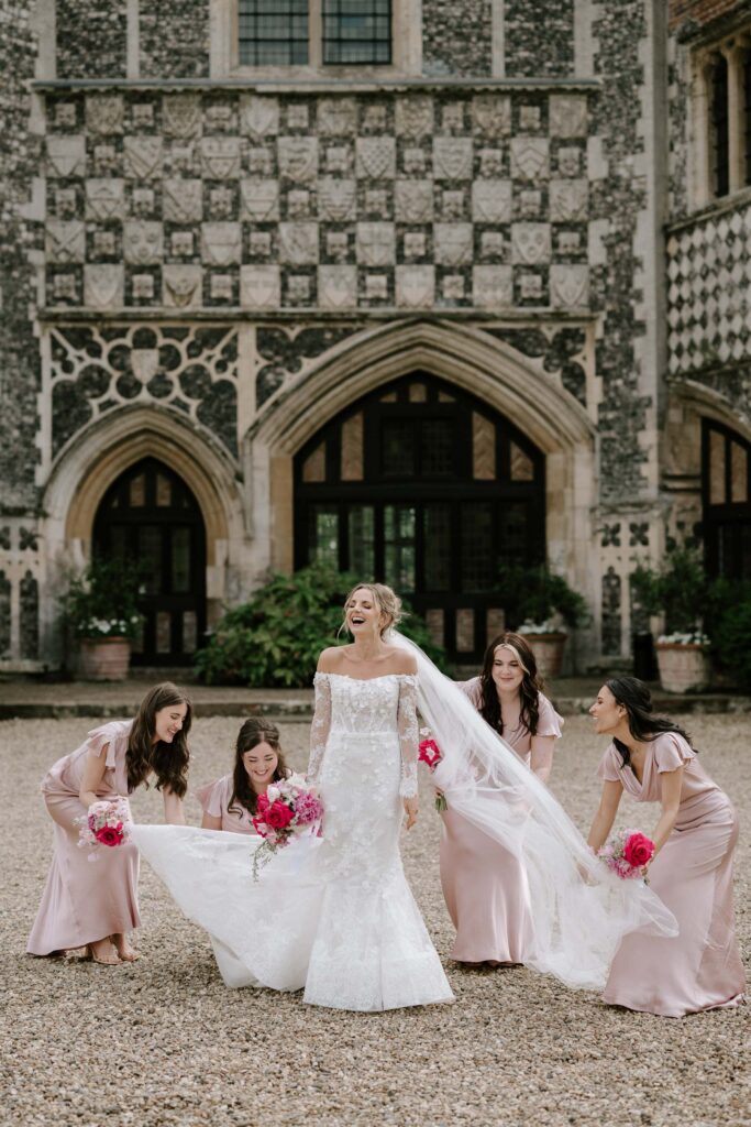 Bride and bridesmaids gathered together outside Butley Priory during group portraits.