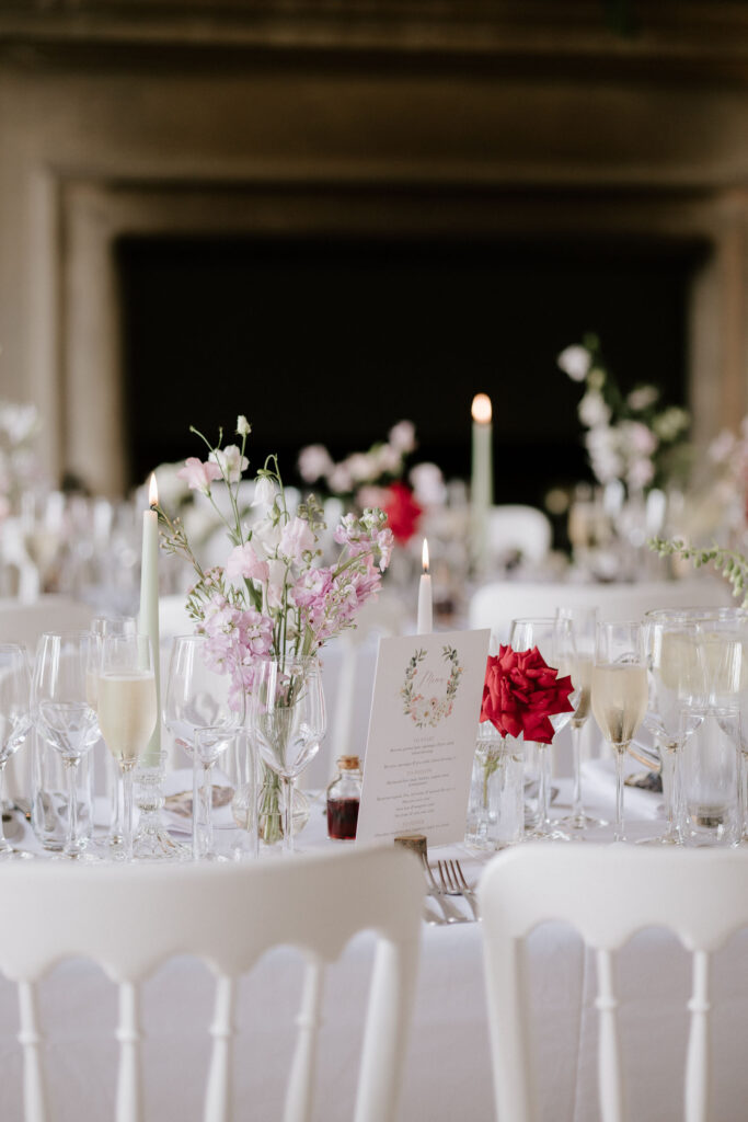 Elegant wedding table details with candles and pink flowers inside Butley Priory.