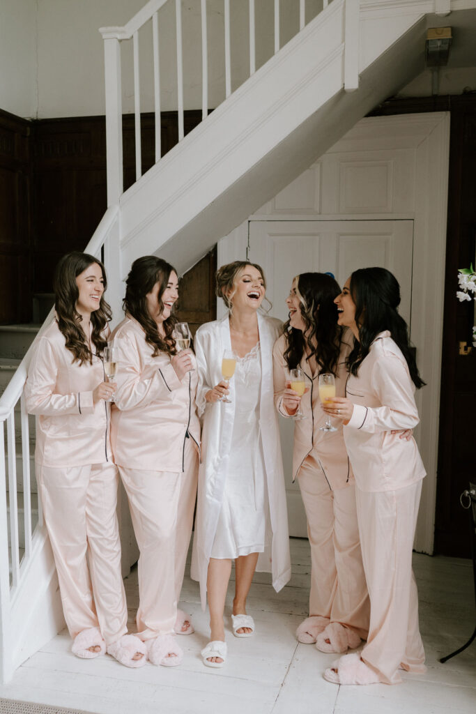 bride laughing with bridesmaids at butley priory