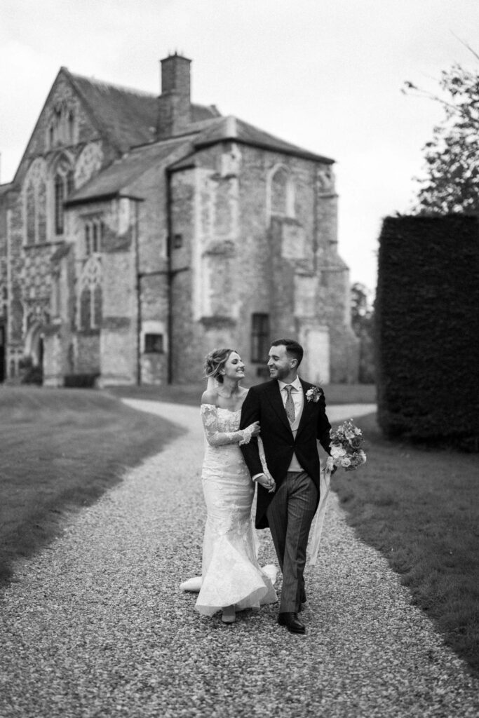 Bride and groom walking together in front Butley Priory