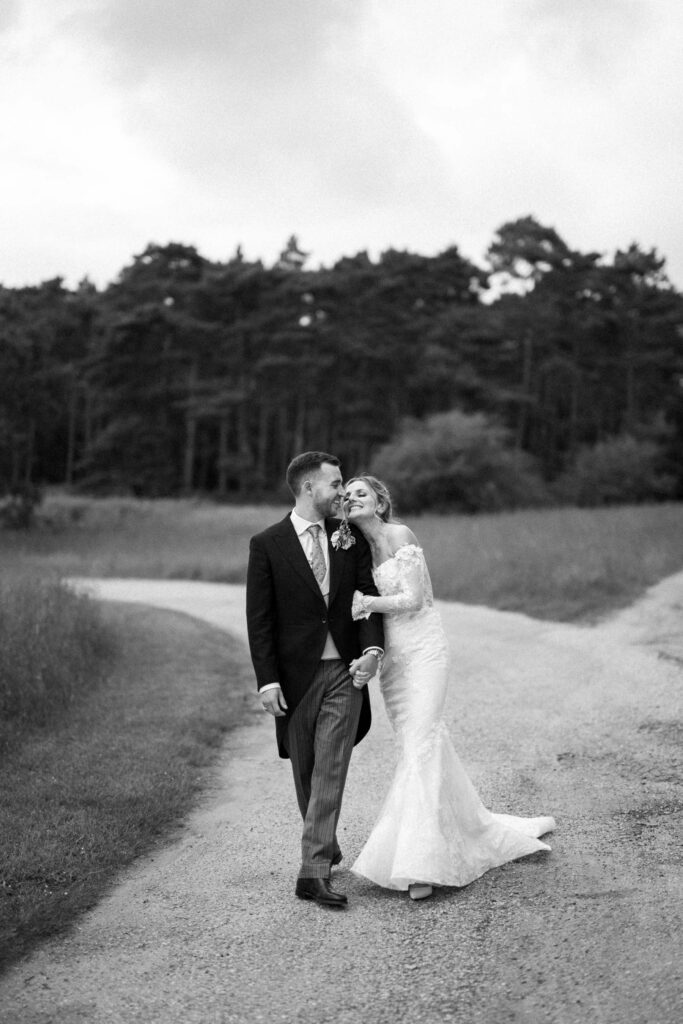 Bride and groom standing together on a country path during couple portraits.