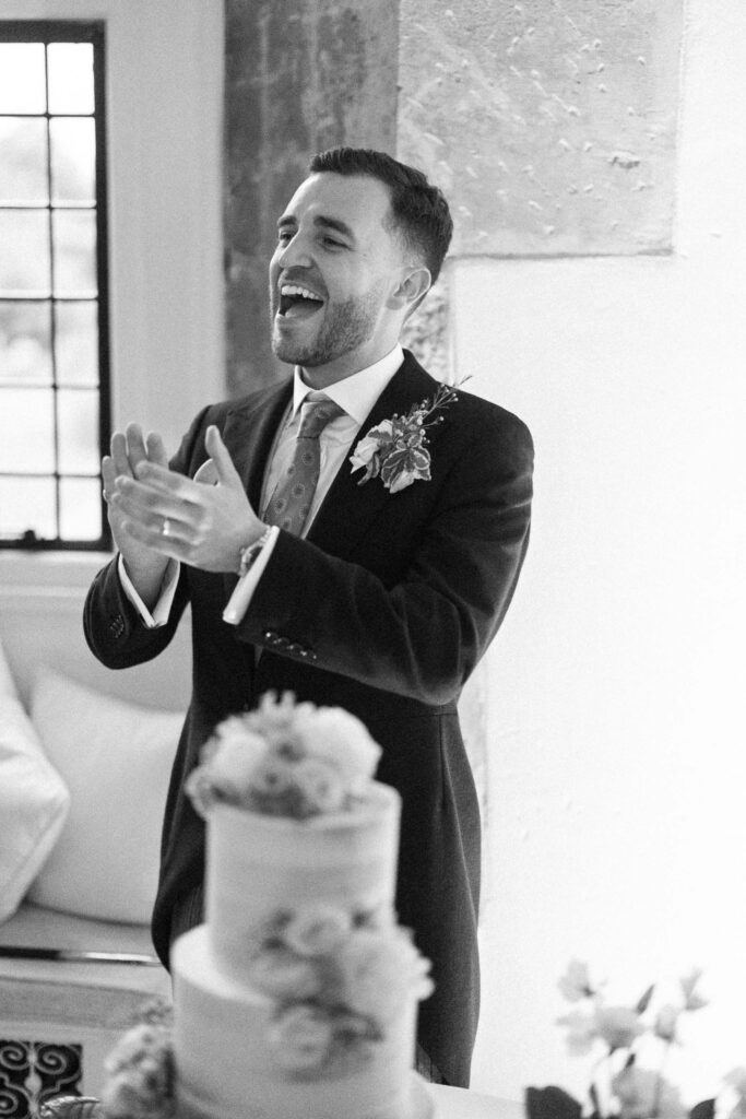 Groom applauding during evening celebrations at the wedding.