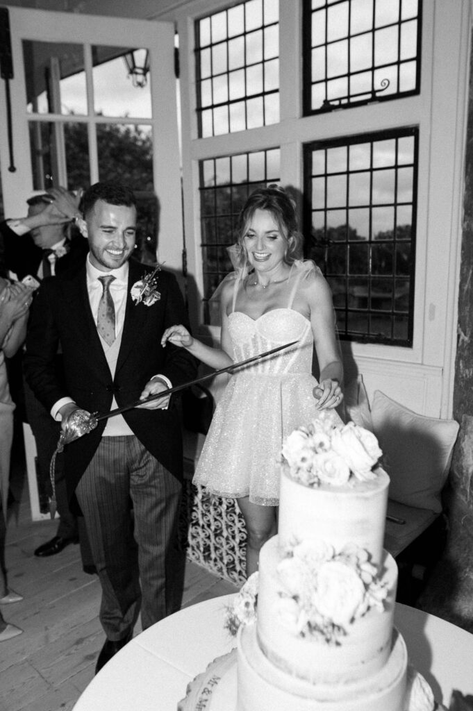 Bride and groom cutting the wedding cake together during the evening celebration.