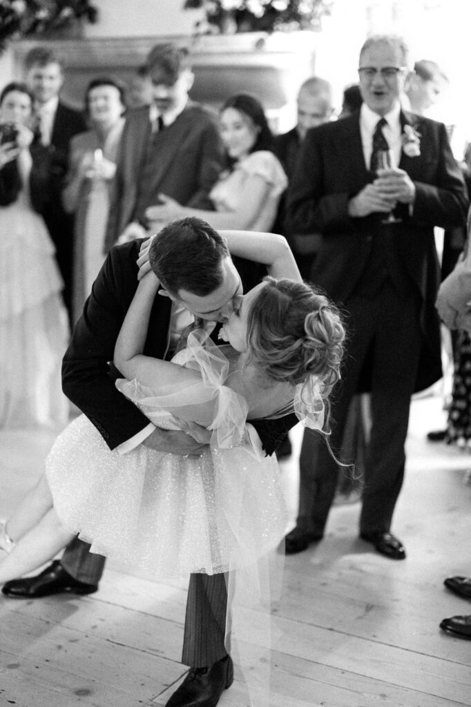 Bride and groom dipping playfully on the dance floor during the reception