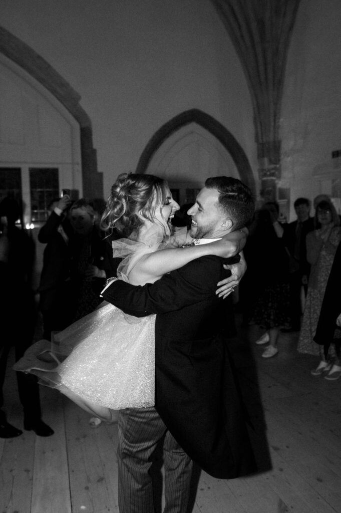 Bride and groom sharing a kiss while dancing during the evening celebration.