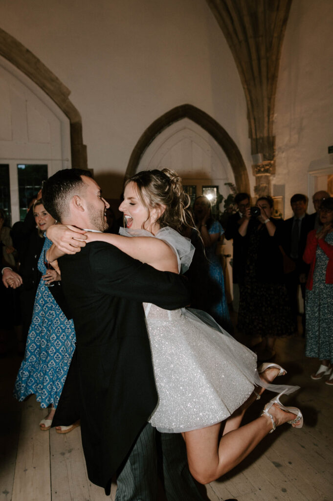 Bride and groom hugging tightly while dancing during the evening reception.