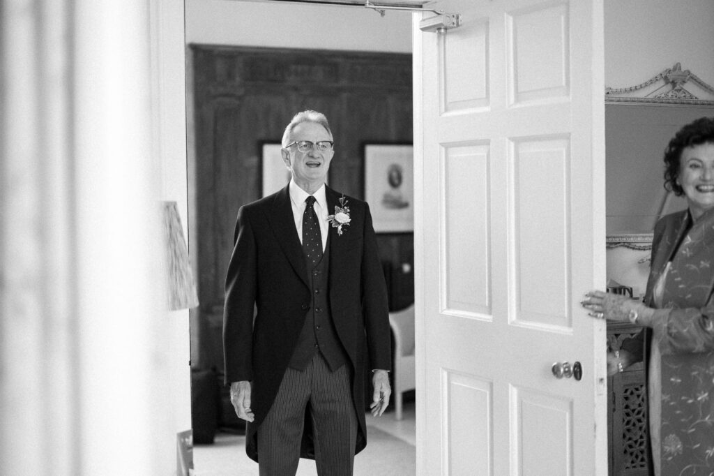 Father of the bride seeing his daughter for the first time on her wedding morning at Butley Priory.