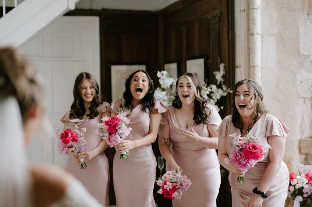 Bridesmaids reacting excitedly during bridal prep at a Butley Priory wedding.