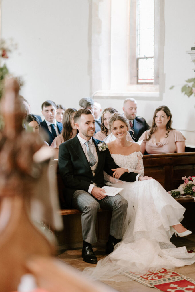 bride and groom at alter sitting down and holding hands