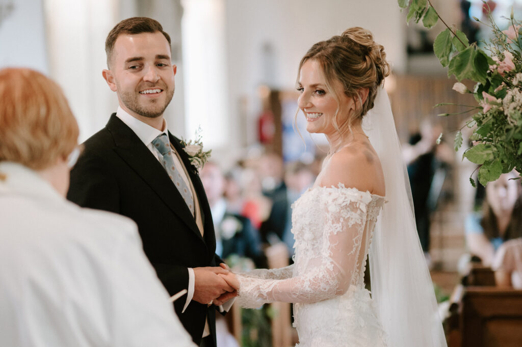 bride and groom smiling at vicar 