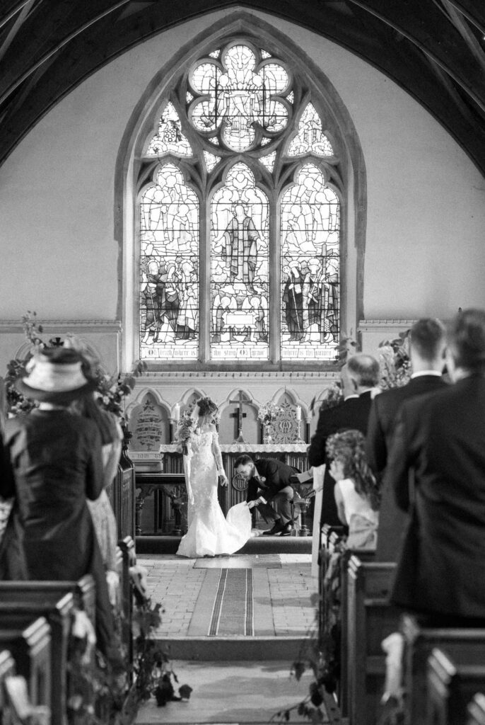 groom arranging the brides dress 