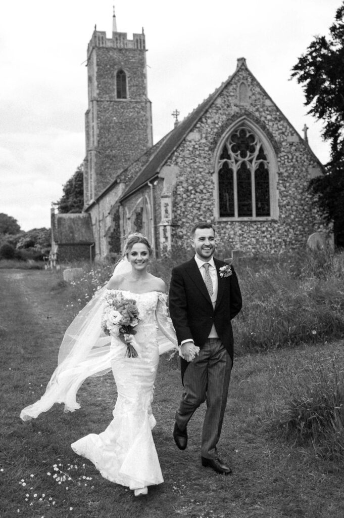 Bride and groom walking together outside the church after their wedding ceremony.
