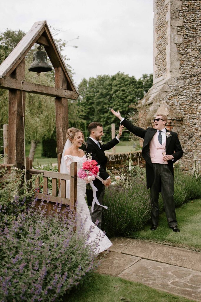 Bride and groom laughing together outdoors at Butley Priory during relaxed portraits.